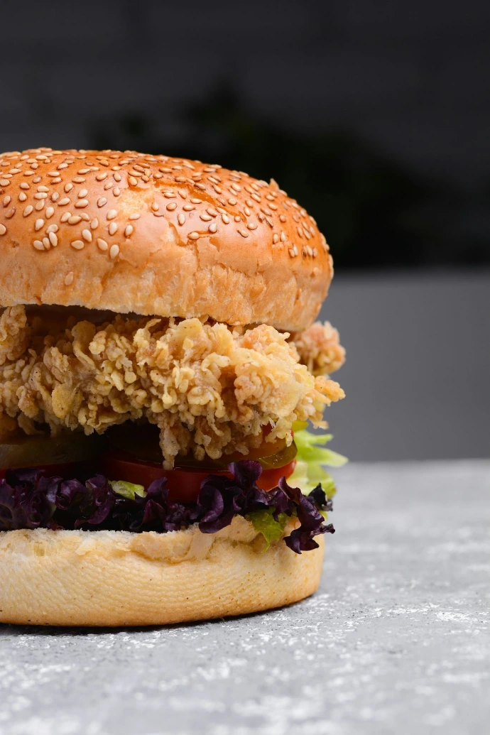 a sesame seed chicken sandwich with lettuce and tomato